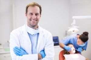 General dentist crossing his arms and smiling looking straight into the camera